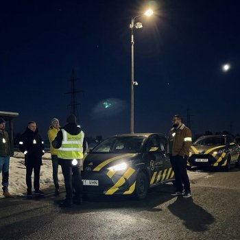 Helkurvestides õppijad ja Autosõidu õppeautod õhtusel platsil